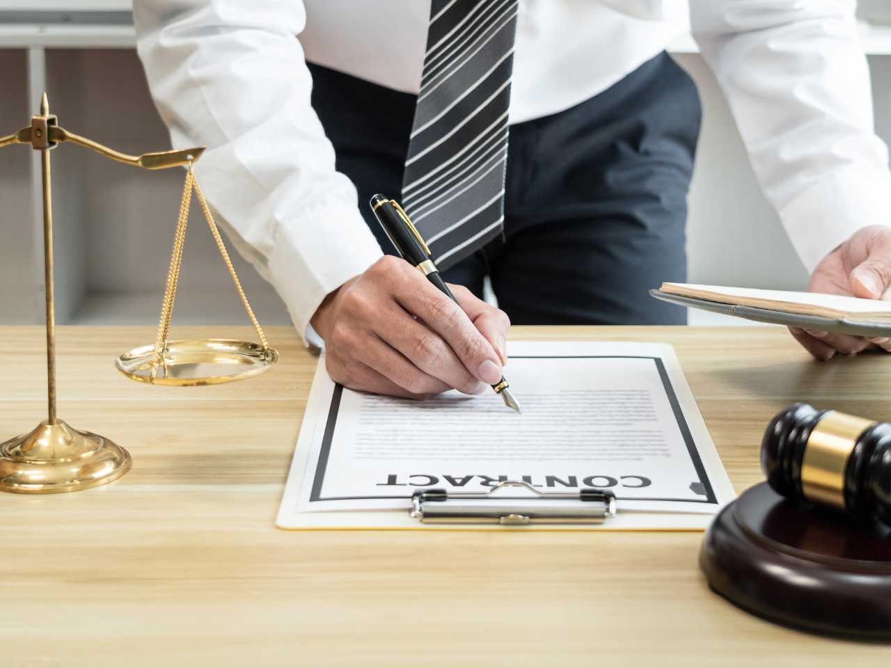 a man stands at a lawyer's desk reviewing a client contract