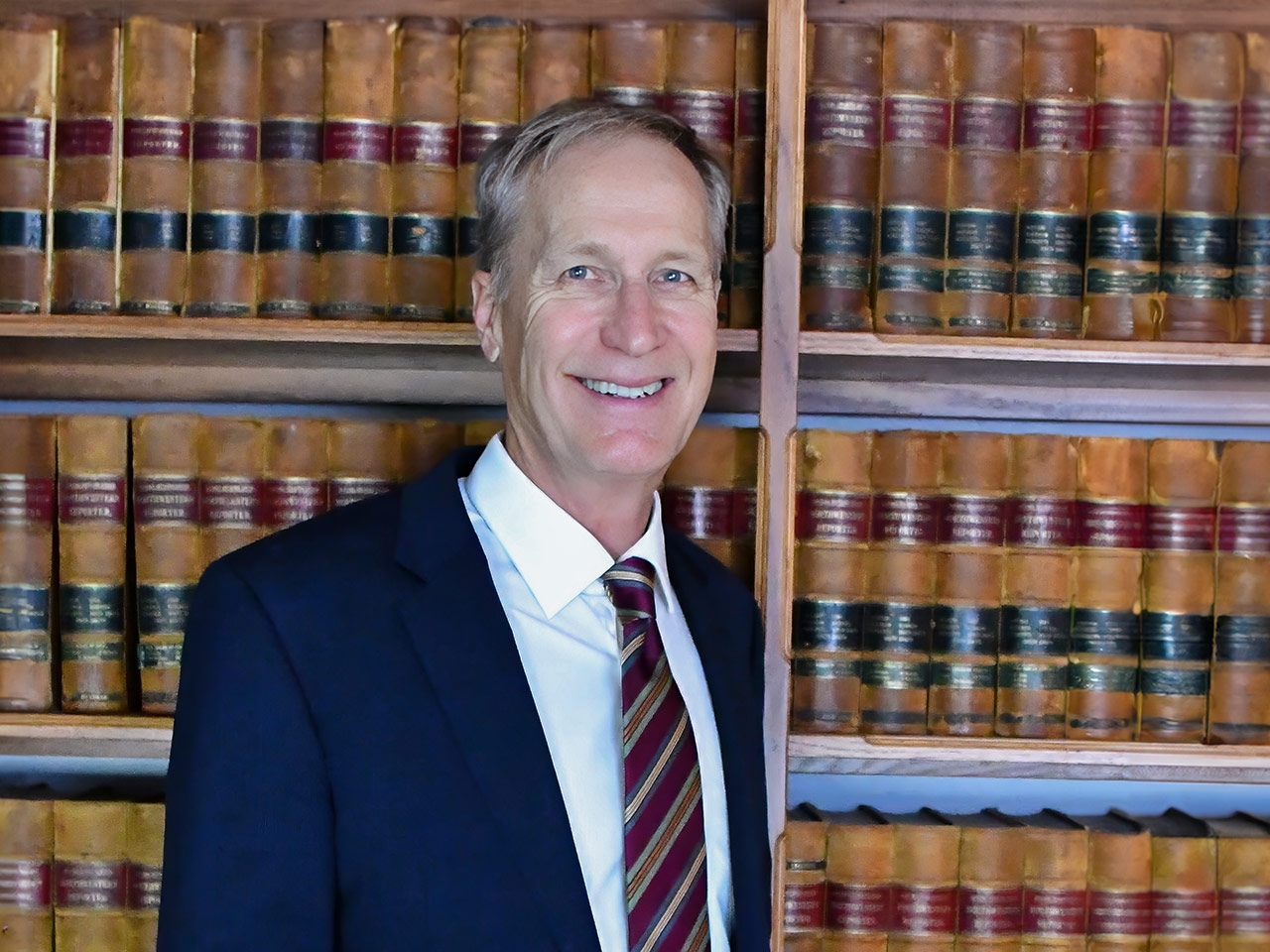 David J. Siegrist leaning on a bookshelf