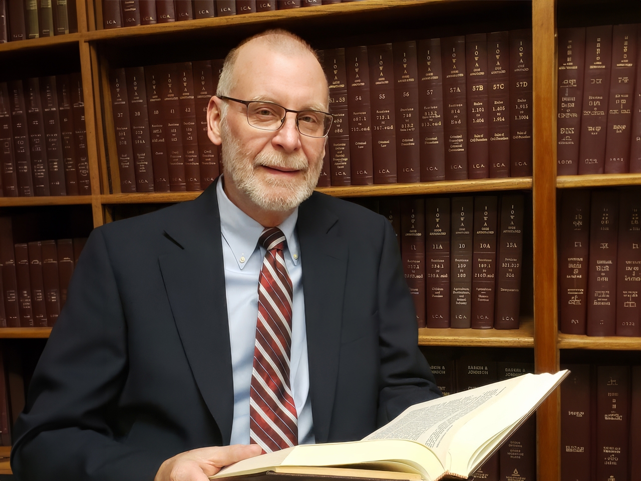staff standing by bookshelf with arms crossed